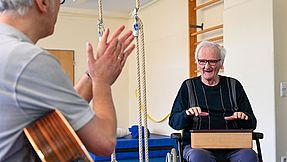 Staff and clients use instruments during music therapy.