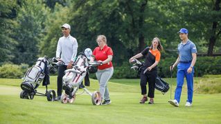 Tufan Sirmagül geht in Begleitung von weiteren Spielern über den Golfplatz. 