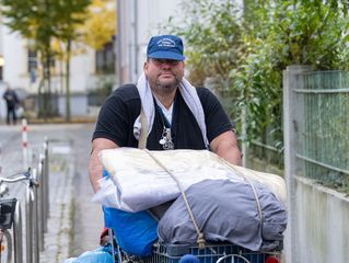 Jens schiebt einen Einkaufswagen mit seinem ganzen Besitz