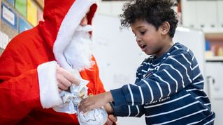 Junge bekommt ein kleines Geschenk vom Nikolaus überreicht