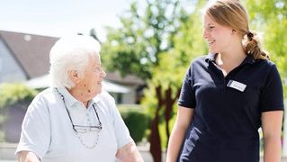 Eine Pflegerin unterhält sich mit einer Patientin.