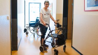  Susanne Boestfleisch walks across the corridor on her walking frame.