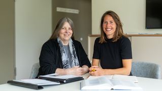 Silke Benter und Katrin Klaphake sitzten am Tisch und lächeln in die Kamera.