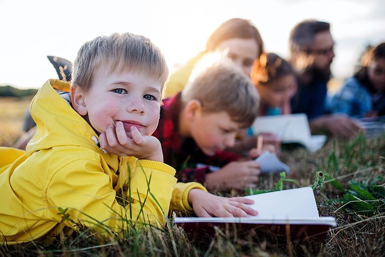 Kinder lernen im Gras