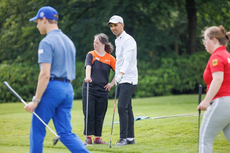 Tufan Sirmagül geht in Begleitung von weiteren Spielern über den Golfplatz. 