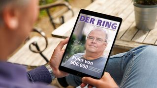 Ein Mann sitzt an einem Tisch und liest die digitale Ausgabe von DER RING.