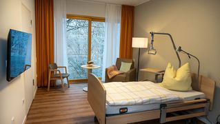 Ein Zimmer mit Bett und großem Fenster.