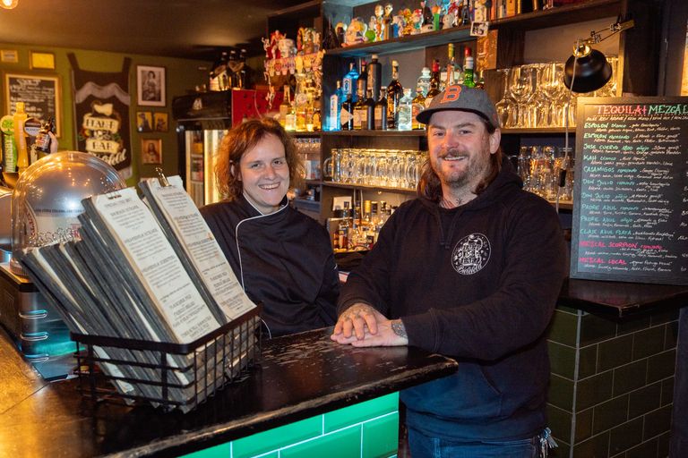 Sonja Schüler und Benjamin Stücke stehen an der Bar und lächeln in die Kamera