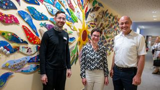 Gruppenbild vor bunter Wand im Kinderhospiz