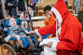 Nikolaus spricht zu Jungen im Rollstuhl