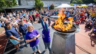 Fackelträgerin zündet die Feuerschale an