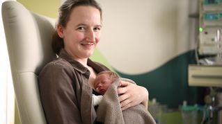 Frau mit Neugeborenem auf der Brust